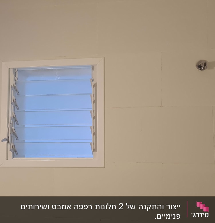חלון עם תריסי אלומיניום על קיר בהיר